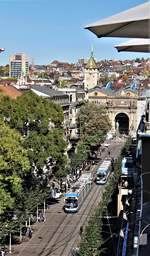 Zürich Bahnhofstrasse: Zwei VBZ Be 5/6  Cobra  als Linie 11 nach Rehalp und Linie 6 nach Zoo, begegnen sich bei der Haltestelle Zürich, Bahnhofstrasse/HB. Etwas weiter hinten sieht man den Eingang des Hauptbahnhof Zürichs zur Bahnhofstrasse. Es ist wohl der schönste und auch der älteste Ein-/Ausgang des HB Zürich, denn wenn man genauer hinschaut, erkennt man einen Springbrunnen mit dem Denkmal eines berühmten Schweizer Pioniers: Alfred Escher. Noch weiter hinten kann man noch das Schweizer Landesmuseum erkennen. Das Bild entstand am 11. Oktober 2017, hoch über den Dächern Zürichs, im obersten Stock des Kaufhauses Modissa an der Bahnhofstrasse. Danach hatte ich im Restaurant eine kurze Kaffeepause.