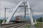 Der SBB RABe 511 019 ist als RE auf dem Weg von St-Maurice nach Annemasse und überquert bei Massogex auf der neuen Rhone Brücke die Rhone.