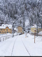 Strecke Le Locle - Besançon auf dem kurzen Schweizer Abschnitt vor dem Grenztunnel am 5. Dezember 2020. Der in Le Locle mit  Retard indéterminé  angekündigte morgendliche TER aus Morteau ist offensichtlich auch nach dem Mittag noch nicht angekommen und auch der Gegenzug nach Besançon ist bis Morteau ausgefallen, wie der immer noch auf den Schienen liegende Schnee bezeugt. Aufnahme vom Bahnübergang.
