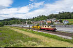 IRSI Re 421 393 bringt am 6. Juni 2020 bei Oberwangen eine Baumaschine von Genf nach Sargans.