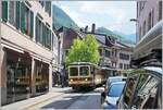 Nochmals der Regionalzug R 25 333 von Leysin nach Aigle bei der Ortsdurchfahrt in Aigle, nun etwas früher ausgelöst und somit ein Spiegelbild des Bt im Schaufenster; Trotzdem verdecken parkierende Autos den Blick auf den Zug. Zur Vervollständigung: der A-L R 25 333 besteht aus aus dem AL Bt 351  Aigle  und dem AL BDeh 4/4 302  Leysin . 

4. Juni 2023