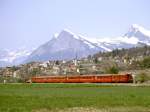 RhB Schnellzug 44 von Davos-Platz nach Landquart vom 25.04.1992 mit E-Lok Ge 4/4II 614 - A - B - A - B - B - B - D. Dieses Foto entstand etwa 20 Sekunden nach obiger Aufnahme, jetzt Rckansicht des Zuges Blickrichtung Malans. Im Hintergrund der noch schneebedeckte Gonzen.