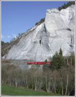 Ge 6/6 II 702  Curia  mit RE 1261 fhrt langsam an der Abbruchstelle vorbei, die gut an der dunklen Frbung in dem
Felssporn erkennbar ist. (17.04.2007)