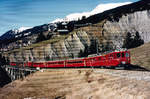 Rhätische Bahn/RhB.
Chur-Arosa Bahn.
Regionalzug mit Doppeltraktion ABDe 4/4 unterwegs nach Arosa im März 1996 kurz vor Langwies beim Gründjitobelviadukt.
Besondere Beachtung gilt dem Spitzenverkehrswagen hinter den Triebwagen sowie dem zweiachsigen Gepäckwagen. 
Ab dem Jahre 1997 sind diese Triebwagen Geschichte wegen der Umstellung des Stromsystems von 2400 V Gleichstrom auf 11 kV 16,7 Hz Wechselstrom.
Foto: Walter Ruetsch
