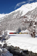 Winterliche Postkartenidylle: Güterzug mit der Ge 6/6 704 vom Engadin Richtung Albula - Chur im Val Bever zwischen Bever und Spinas. Bever, 10.12.2020