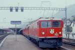 RhB Schnellzug 550 von St.Moritz nach Chur am 27.05.1988 in Samedan mit E-Lok Ge 6/6 II 703 - Ge 4/4 II 633 - 2x A - 3x B - D - 2x A - 6x B. Hinweis: Vorspannlok aus Lastgrnden (310t Zughakenlast),  gescanntes Dia

