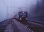 Ge 4/4 III Nr.622 taucht mit ihrem Schnellzug aus dem Nebel auf.