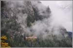 Der verspätete Glacier Express 905 taucht aus einer tiefhängenden Wolke auf oberhalb von Filisur. (07.10.2015)