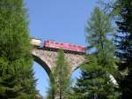 Einen recht schweren Gterzug bringt am 14.04.2006 die Ge 6/6 II 704  Davos  nach St. Moritz. Hier berquert sie den Albula 2-Viadukt. Das Foto entstand vom Bahnlehrpfad Preda-Bergn aus. Es empfiehlt sich nicht unbedingt ausschlielich die ausgeschilderten Fotostellen zu nutzen. Direkt am Weg liegen auch schne Stellen versteckt. 