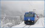 Im tiefverschneiten Alvaneu im Alkbulatal berholen wir einen Extrazug mit Ge 4/4 III 647  Grsch .