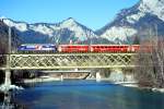 RhB Schnellzug 551 von Chur nach St.Moritz am 27.02.1998 auf Rheinbrcke bei Reichenau mit E-Lok Ge 4/4 III 644 - D- 3x B - 2x A - Lokwerbung: UNERHRT - Hinweis: gescanntes Dia  