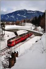 S2 1564 von Thusis nach Chur fhrt zwischen Bonaduz und Reichenau-Tamins talwrts. Die Fussgngerbrcke ersetzt seit kurzem einen unbewachten Bahnbergang. (15.02.2013)