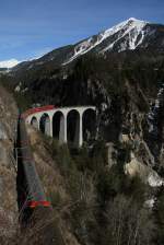 Ge 4/4 III 651  Fideris  der Rhätischen Bahn (RhB) mit Werbung  Glacieren Tour - Zermatt - St.Moritz  auf der Albula-Strecke auf dem Landwasserviadukt am 9.3.2015.