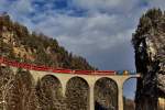 Ge 4/4 III 652  HCD  fährt mit einem GEX über das Landwasserviadukt in Filisur.Bild vom 19.1.2016