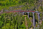 Ge 4/4 III 650  Unesco Weltkulturerbe  überfährt mit einem Re von Chur nach St.Moritz das Landwasserviadukt in Filisur dessen Antlitz diese schöne RhB Elektrolokomotive ziert.Bild vom