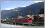 Ge 6/6 II 705  Pontresina/Puntraschigna  mit einem Gterzug nach Samedan im Engadin. Nicht alles Holz ist fr die Grosssgerei Stallinger bestimmt, die sich links vom Zug befindet. Das eher minderwertige Holz im Hintergrund wird im Biomassekraftwerk der Ems Chemie verwendet und die Rundholzstmme auf dem Zug sind fr den Export bestimmt und nehmen den weiten Weg ber Albula und Bernina ins italienische Veltlin. (24.05.2007)