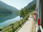 Blick aus dem ABe 4/4 Nr.51 auf den Lago di Poschiavo.zwischen Le Prese und Miralago auf der Fahrt nach Tirano.Neben dem Zug die Reste der alten Strasse,die heute nur noch von Wanderern und