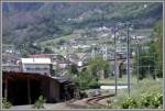 Vom Berninapass her nhert sich ein Regionalzug mit Gterlast der Station Brusio, die sich oberhalb des Kreisviadukts bei der Kirche befindet.