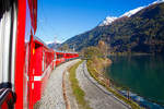 
Auf der Rückfahrt, bei und bestem Kaiserwetter....
Geführt von den beiden RhB ABe 4/4 III Triebwagen, Nr. 53  Tirano  und Nr. 54  Hakone , fährt unser RhB Regionalzug von Tirano nach St. Moritz, am Lago di Poschiavo entlang.