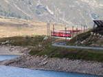 Von der Sonne in den Schatten: Regionalzug von St. Moritz nach Tirano fährt nicht nur vom Hellen ins Dunkle, sondern in jener Region auch über die Wasserscheide 'Adriatisches bzw Schwarzes Meer'. Ospizio Bernina (2253 müM), 7.8.2025