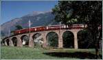 Zwei ABe 4/4 II fahren mit einem Bernina Express der neunziger Jahre ber das Kreisviadukt von Brusio talwrts.