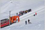 Der ausgefahrene Rumer leitet den Schnee in die Mitte des Geleises, von wo er anschliessend durch die Schneeschleuder weggeschleudert wird und die Fotografengruppe ahnt noch nichts vom kommenden Unheil. (26.02.2011)