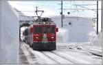 R1636 mit ABe 4/4 III 55  Diavolezza  erreicht Ospizio Bernina. Die gedeckte Drehscheibe im rechten Gebäudeteil ist total eingeschneit. (21.02.2014)