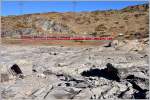 Der R1625 mit den beiden ABe 4/4 III 54  Hakone  und 55  Diavolezza  und den Wagen des Bernina Express ab Chur in der Steinwüste am Ufer des Lago Bianco.(10.12.2015)