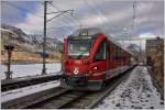 Eine wirklich hauchdünne Schneeschicht hat sich am Berninapass auf See und Perron gelegt, als der R1621 nit ABe 8/12 3515 einen kurzen Halt einlegt.