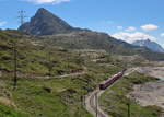 Durch eine karge Landschaft fährt ABe 8/12 3514  Steivan Brunies  als R1640 (Tirano - St.Moritz).