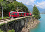 Der Regionalzug von St. Moritz nach Tirano fährt hier zwischen Le Prese und Miralago dem Lago di Poschiavo entlang. Hier verläuft ein breiter Weg direkt neben dem Gleis. Le Prese, 21.8.2023