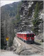 R1644 mit ABe 4/4 III  Brusio  und einem ABe 4/4 II erreichen bald Cavaglia. Rechts ber diesem Felskopf befinden sich die Gletschermhlen, die mit Treppen und Leitern fr Besucher zugnglich gemacht wurden. (06.05.2009)