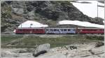 Asterix und Obelix haben ihren Hinkelstein auf dem Berninapass verloren. Dahinter R1646 mit ABe 4/4 III 51 und 56 auf dem Weg nach Ospizio Bernina. (18.06.2009)