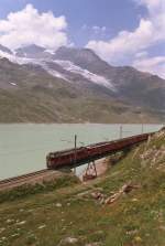 Vor majesttischer Bergkulisse berquert die Berninabahn am Lago Bianco auf ber 2200 Metern ber Meer diese Brcke.