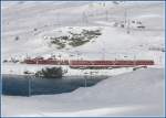 Fr die folgenden Aufnahmen habe ich mir nasse und kalte Fsse eingehandelt, habe ich doch nicht schon mit soviel Schnee gerechnet auf dem Berninapass. ABe 4/4 II 42 und 43 sind mit BEX970 am Lago Bianco Richtung St.Moritz unterwegs. (11.11.2009)