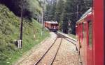 Personenzug Tirano - Pontresina wartet zwischen Bernina-Pa und Pontresina an einer Ausweichstelle auf einen Gegenzug. Mai 2000