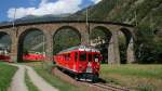 ABe 4/4 48 + 44 mit R 1633 am Haken unterqueren am 09.08.2010 das Kreisviadukt Brusio in Richtung Tirano.