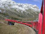 Ein langer Regionalzug erklimmt die 70 Promille Steigung zwischen Bernina Lagalp und der Passhhe. An diesem 18.09.2001 liegt bereits der erste Schnee.
