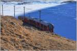 R1648 mit ABe 8/12 3515 kurz vor Ospizio Bernina mit dem gefrorenen Lago Bianco im Halbschatten.