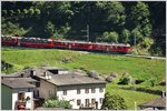 BerninaExpress 973 mit den beiden ABe 4/4 III 55  Diavolezza  und 53  Brusio  passiert etwas oberhalb des Kreisviadukts von Brusio die Crotti, wo früher Lebensmittel gelagert wurden.