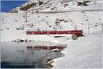 R1648 mit ABe 4/4 III 54  Hakone  und 55  Diavolezza  am Ufer des schwarz gefrorenen Lago Bianco bei Ospizio Bernina. (07.12.2016)