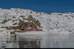 Regio 1648 Poschiavo - St. Moritz wird am 29. Dezember 2016 von einem Allegra als Alleinfahrer geführt. Hier befindet sich der Regionalzug kurz vor Ospizio Bernina am schwarz gefrorenen Lago Bianco.