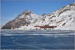 R1625/BEX953 mit ABe 4/4 III 52  Brusio  und 51  Poschiavo  auf der Brücke am zugefrorenen See bei Ospizio Bernina. Dahinter erhebt sich der Piz Albris. (22.12.2016)