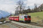 Mit einem Regio aus Pontresina erreicht die Ge 4/4 II 611 am 02.04.2022 Scuol-Tarasp. Auf den Seitenwänden wird für Lehrstellen im Verkehrsbereich geworben.
