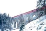 RhB REGIONALZUG von Scuol nach St.Moritz am 12.04.1998 auf Val Susauna-Viadukt mit E-Lok Ge 4/4II 623 - D - 2B - A - B.Hinweis: Ostersonntag bei Schneefall.