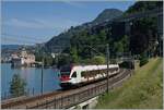 Der SBB RABe 523 021  La Veveyse  ist kurz nach Villeneuve vor der Kulisse des Château de Chillon auf dem Weg in Richtung Lausanne.