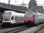 SBB - Im Bahnhof Rotkreuz der Treibzug 523 013-6 nach Baar wird berholt von der 460 037-5 mit dem IR nach Zrich am 10.04.2010