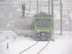 Eine Nina-Komposition kmpft sich am 22.02.2009 mit rund 15 Minuten Versptung durch das Schneegestber im Bahnhof Spiez.