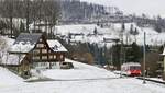 An einem typischen Appenzeller Bauernhaus vorbei fährt der AB-BDeh 3/6 23 am 27.02.2023 hinunter nach Rorschach