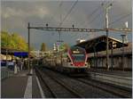 Der SBB RABe 511 115 in Vevey auf Gleis 4 vor der Kulisse dunkler Wolken welche noch ein Stücke Regenbogen ziert.